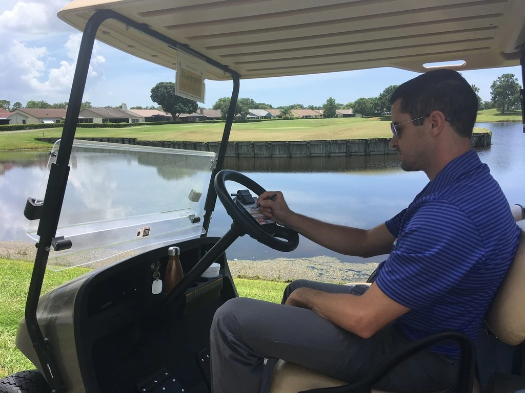 person driving golf cart on course